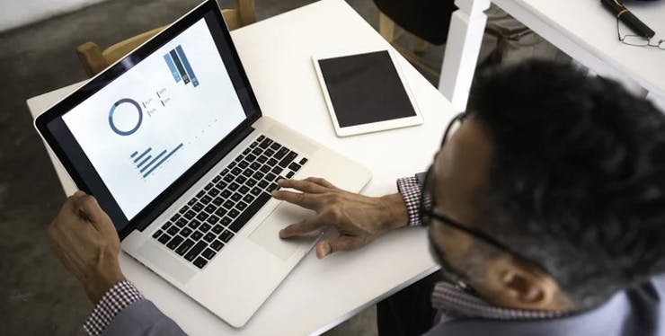 Homem usando um computador com gráficos na tela