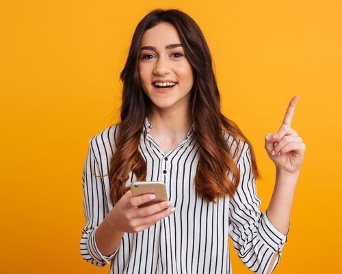 Mulher sorridente segurando um celular.