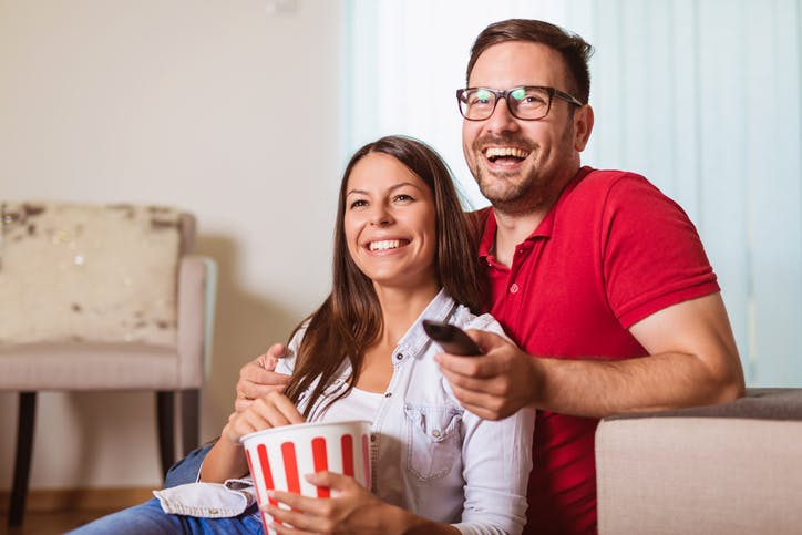 Recarga SKY: Homem e mulher assistem TV enquanto comem pipoca