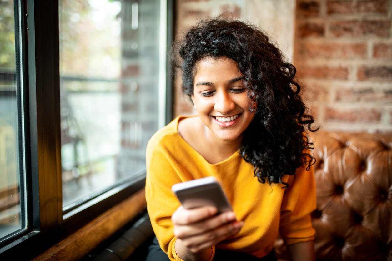 Mulher no celular vendo Planos Vivo Pós