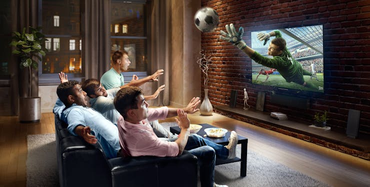 Grupo de homens assistindo um jogo de futebol