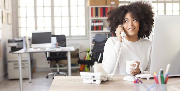 Mulher utilizando o telefone fixo