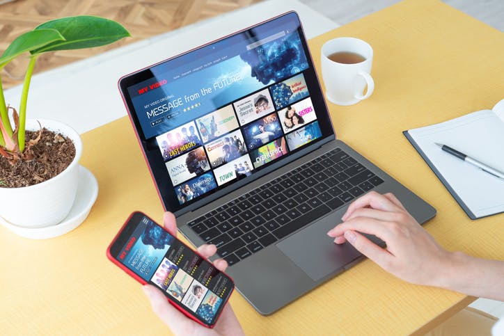 notebook e celular logado em streaming de vídeos