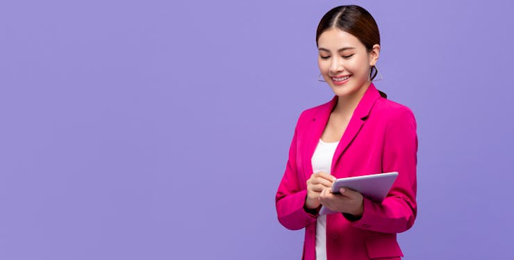 Mulher com roupa social e tablet em mãos.