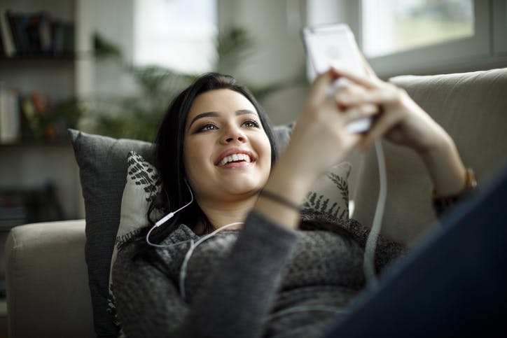 Mulher deitada usando celular