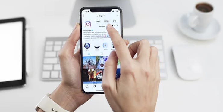 mão de uma pessoa segurando o celular usando o Instagram