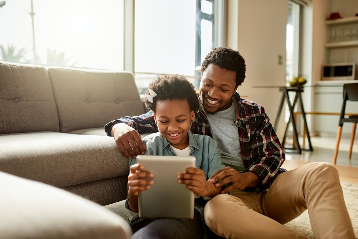 pai e filha vendo tablet