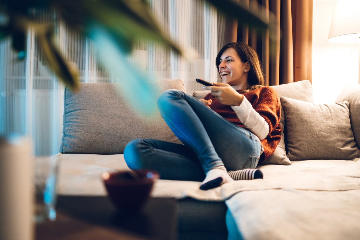 Mulher no sofá aproveitando Plano Vivo TV