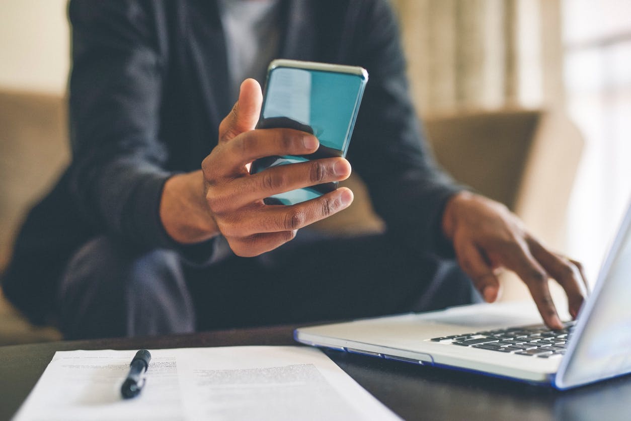 Homem com celular na mão consultando plano Claro