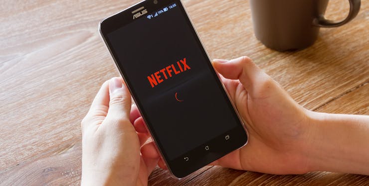 Plano Netflix: pessoa segurando celular com a tela na Netflix