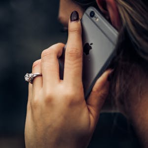 mulher fala ao telefone usando os benefícios tim