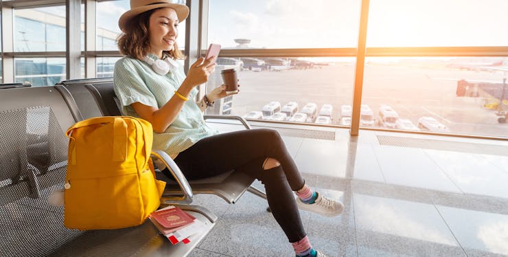 mulher usando o celular em um aeroporto