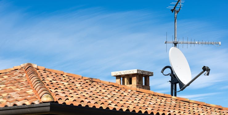 Imagem mostrando uma antena da SKY em um telhado.