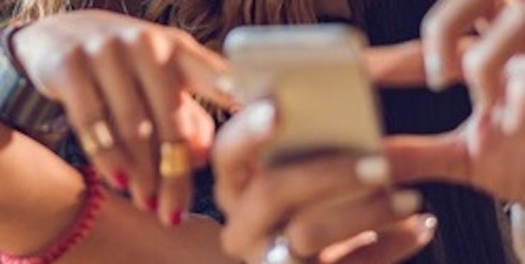 Mãos femininas mexendo no celular