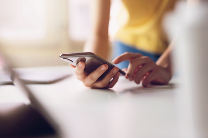 Mulher digitando no celular com plano Claro Controle