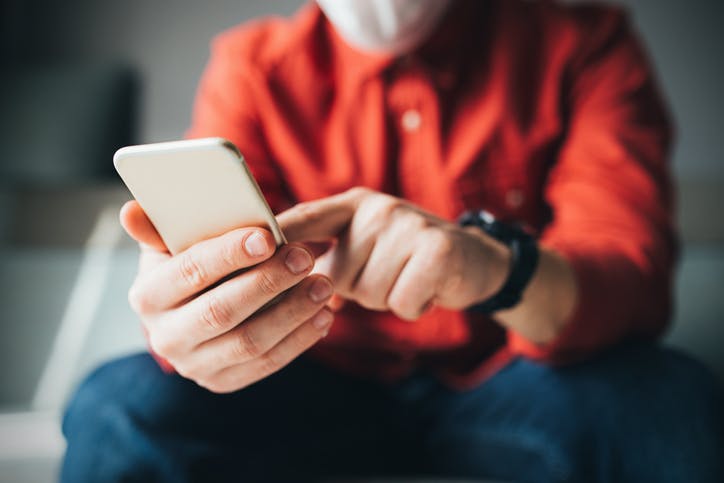 Homem sentado mexendo no aplicativo Minha Claro no celular