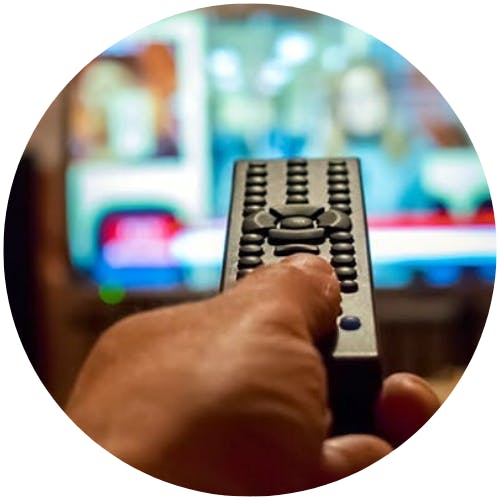 pessoa segurando um controle remoto assistindo tv