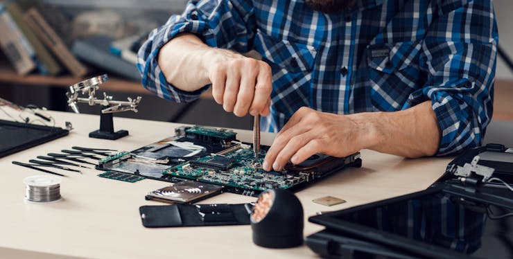 Homem mexendo em placa de hardware