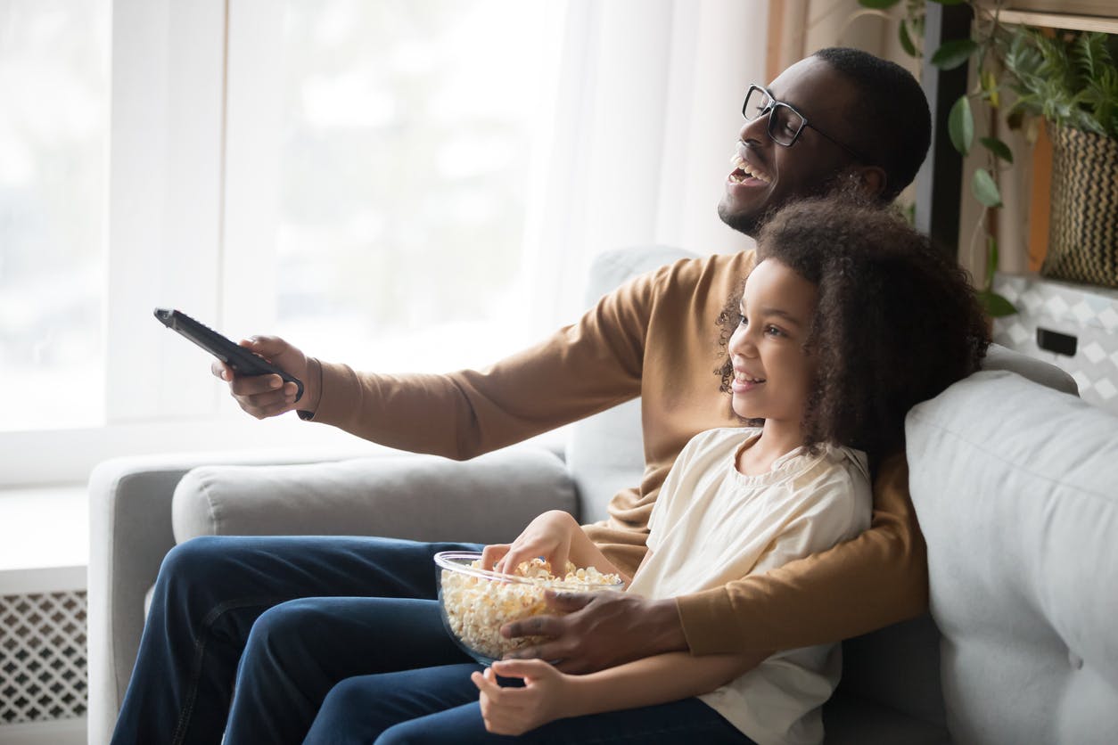 Pai e filha vendo TV aproveitando o Plano Vivo Combo