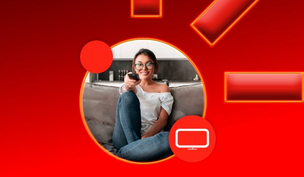 mulher mexendo no controle remoto sentada no sofá