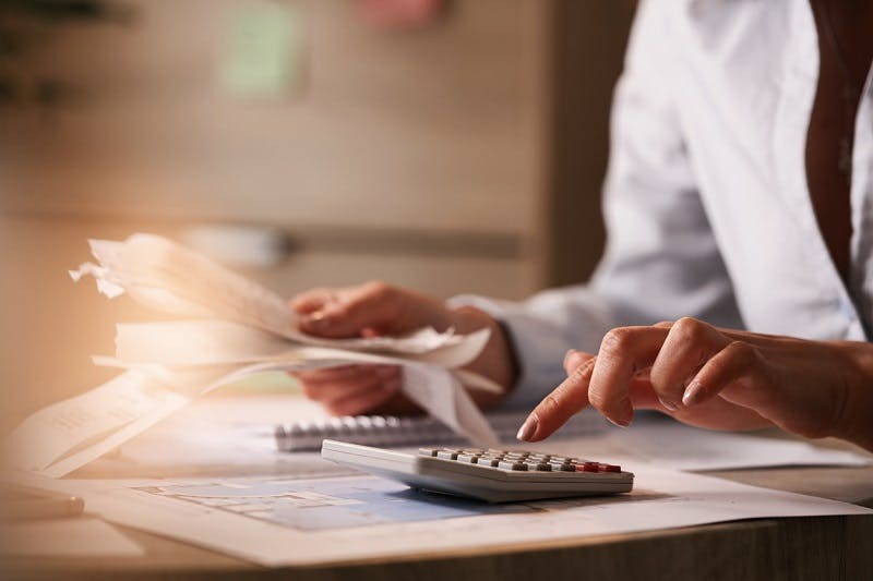 Mulher fazendo contas para pagar as faturas no internet banking