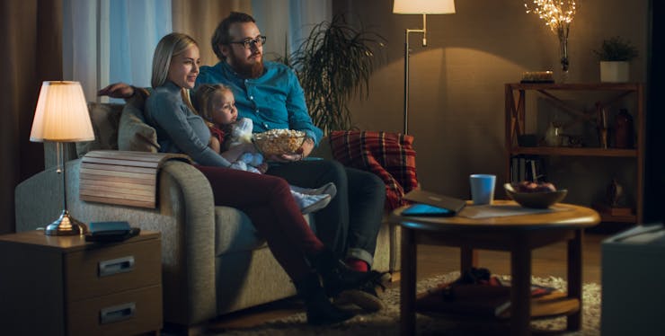 familia come pipoca enquanto assistem tv