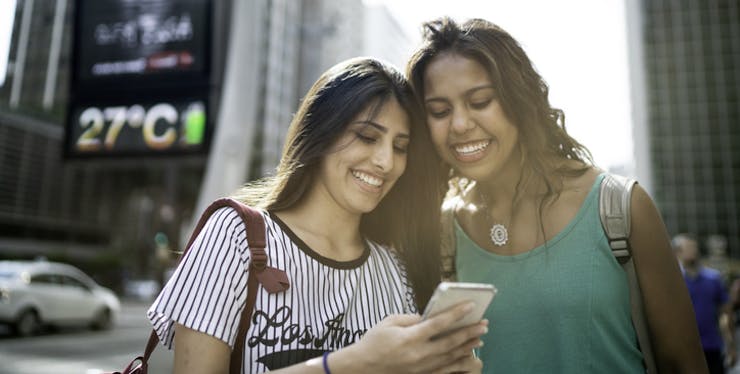 Duas mulheres olhando para celular