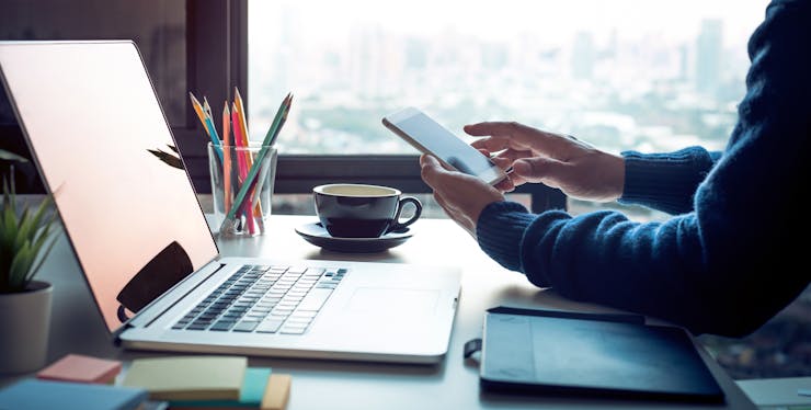 Pessoa usando o computador e smartphone mesa de escritório