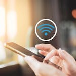 mão mexendo no celular e o símbolo do wi-fi