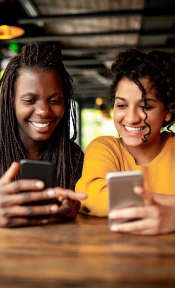 Mulheres com celulares com TIM Black Família