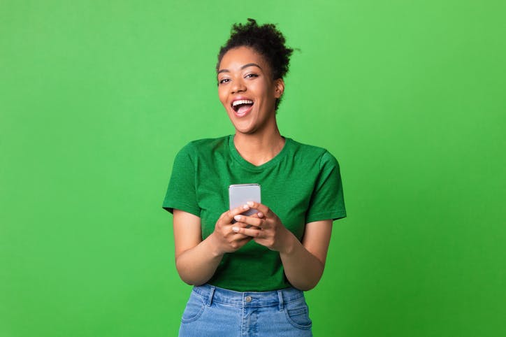 Mulher sorridente segurando celular.