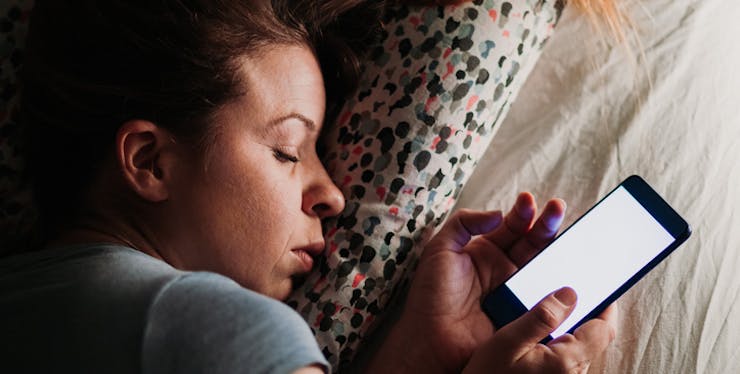 Woman sleeping with cell phone in hand
