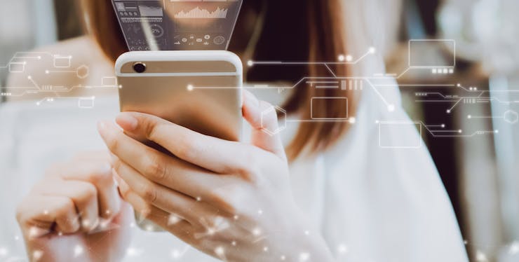 Mulher segurando um celular com ícones de tecnologia