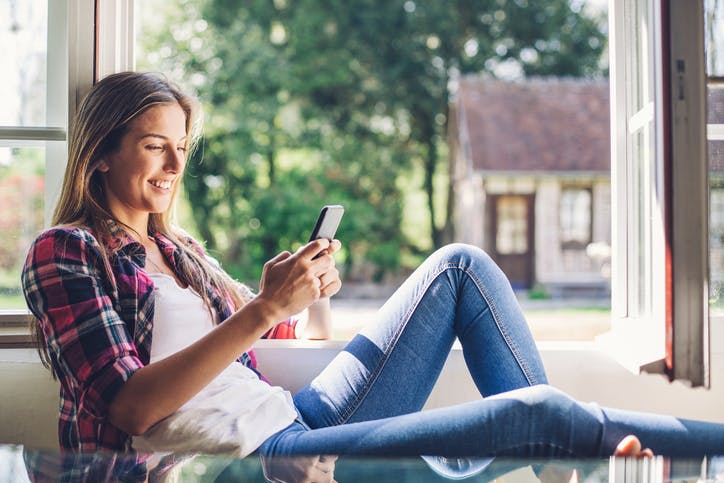 Mulher usando celular Claro