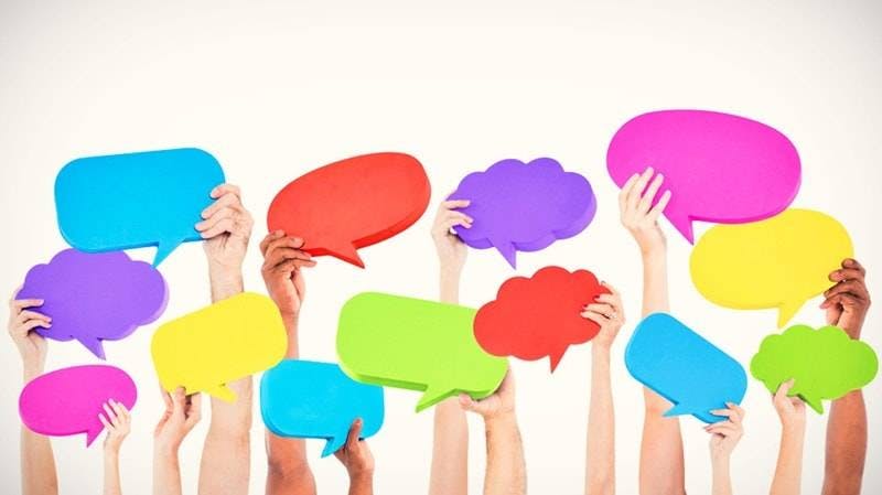 Mãos segurando balões de fala colorido