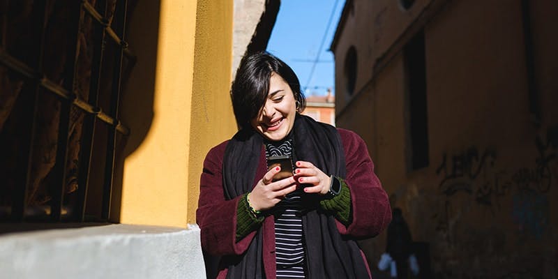 mulher sorridente utiliza plano tim pós-pago