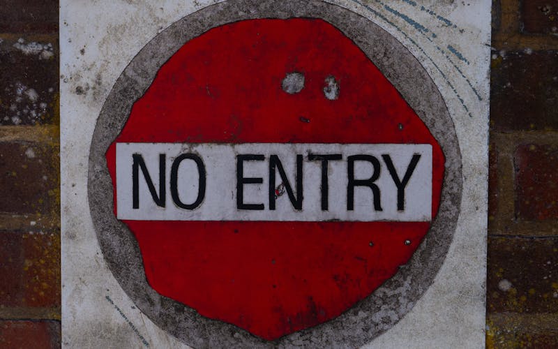 no entry sign fastened to brick wall