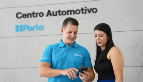 Especialista em um Centro Automotivo, mostra um detalhe no celular para uma cliente.