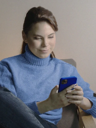 Imagem de mulher sentada numa poltrona navegando na área de investimentos da PortoBank