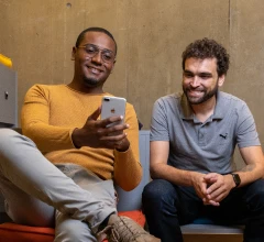 Dois homens conversando, olhando em um celular
