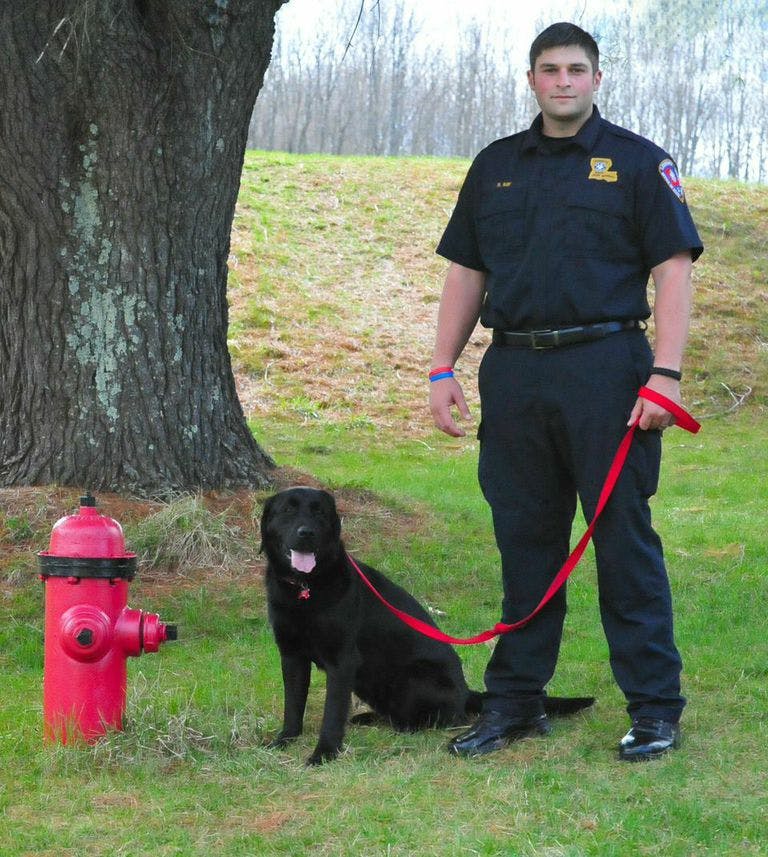 Fire Marshall Roman Ray and Arson Dog, Billy, outside by a fire hydrant