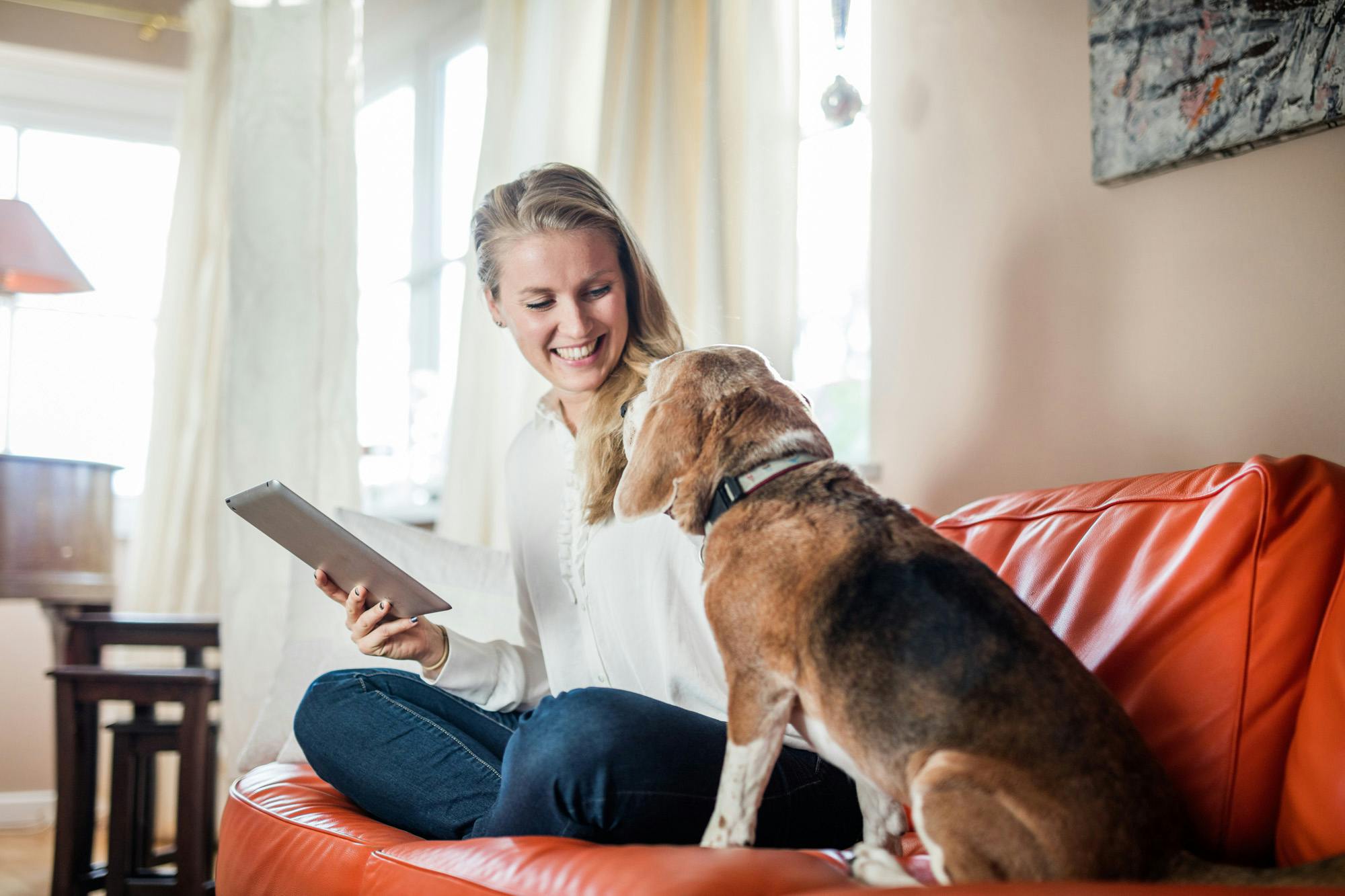 woman and dog sitting on couch making eye contact