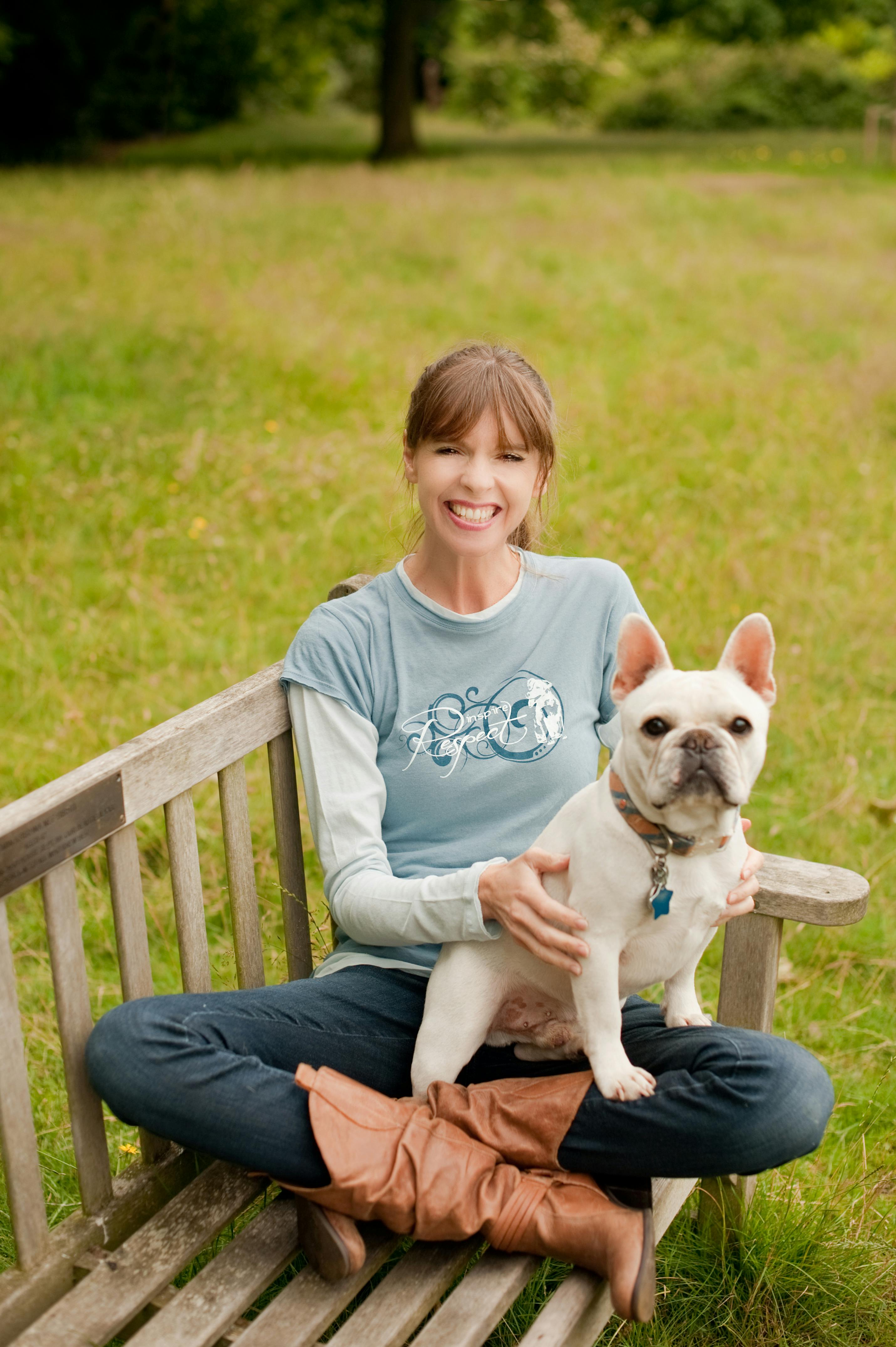 Victoria Stilwell sitting with french Bulldog on bench