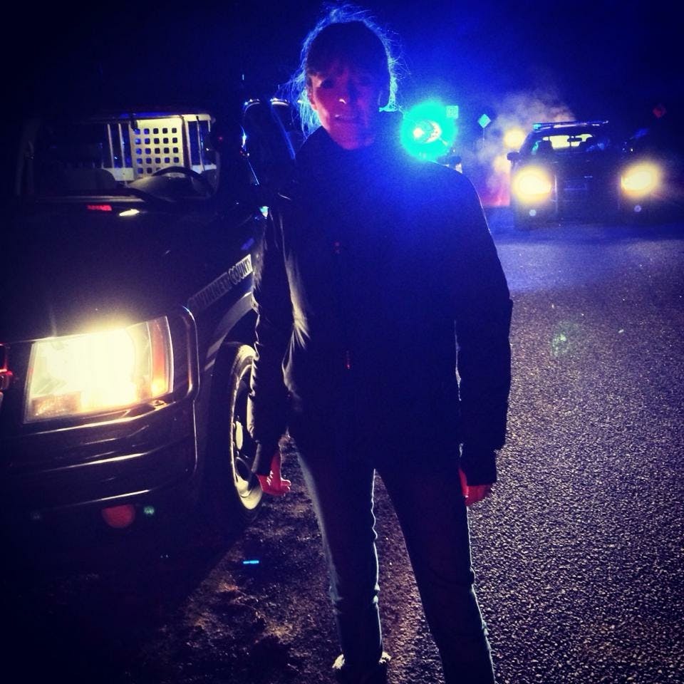 Victoria Stilwell outside at night surrounded by police cars 