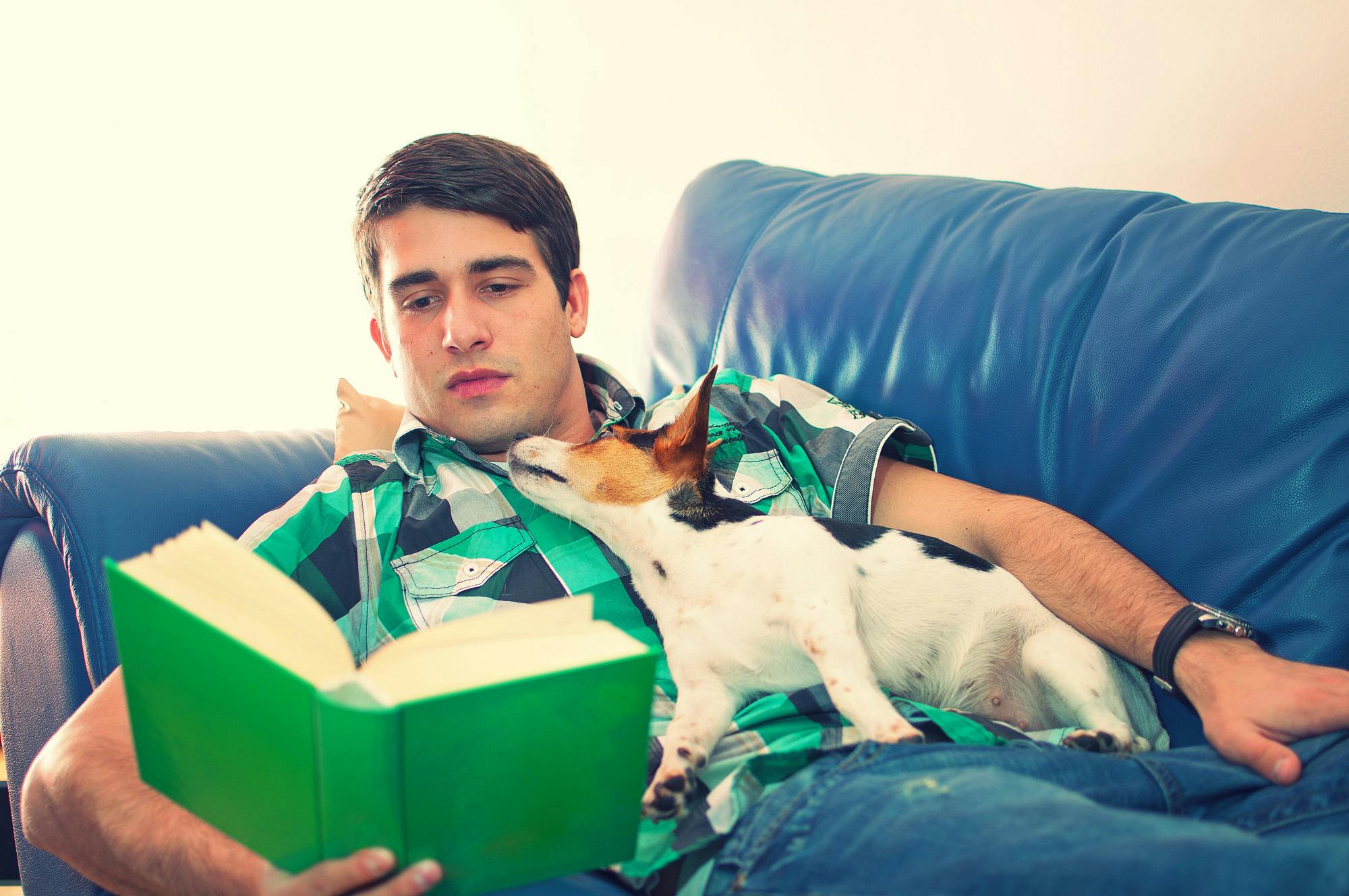 Man reading while his dog is looking up at him