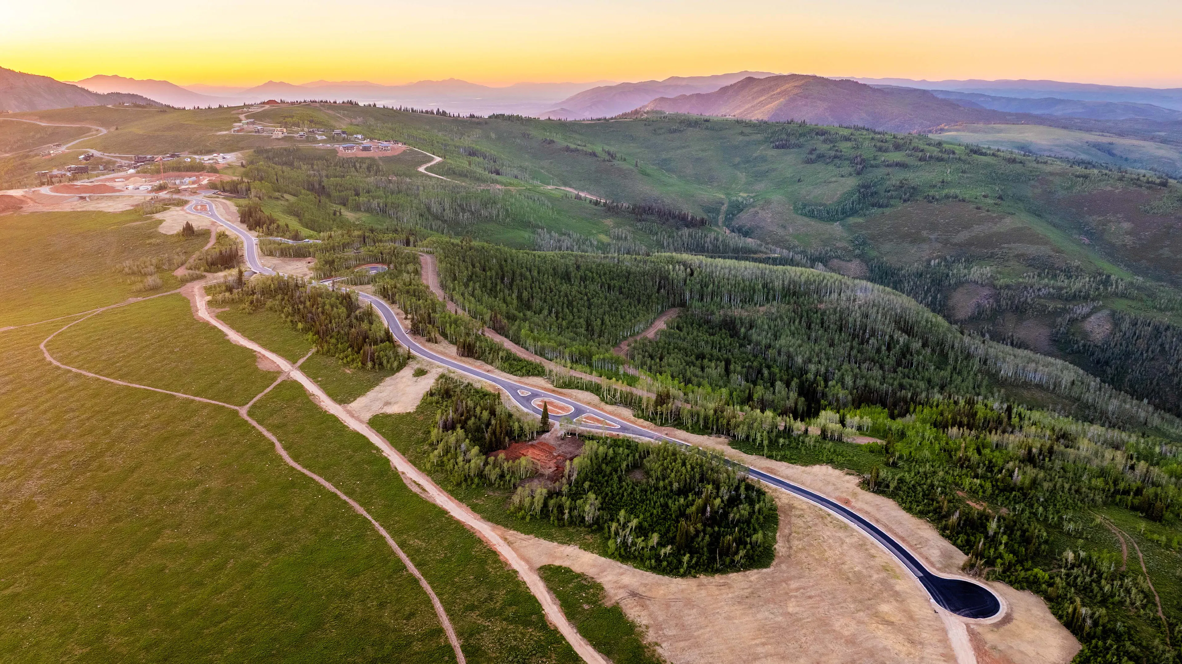 Aerial view of a winding mountain road and forested terrain within the Shelter Hill neighborhood.