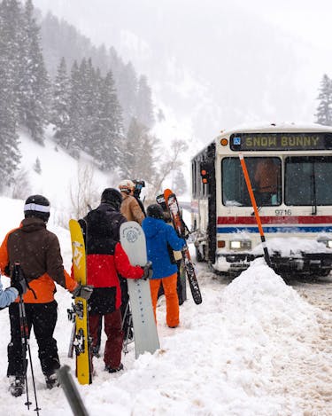A line of skiers and snowboarders waits to board the Powder Mountain shuttle