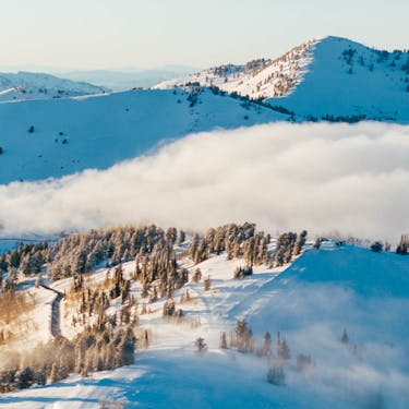 Clouds rolling over snowy mountain peaks