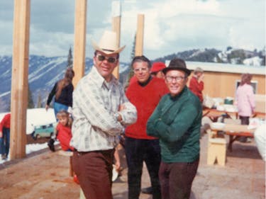 Three men pose in a construction site