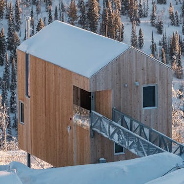 Horizon cabin at dawn, with snowy trees in the background